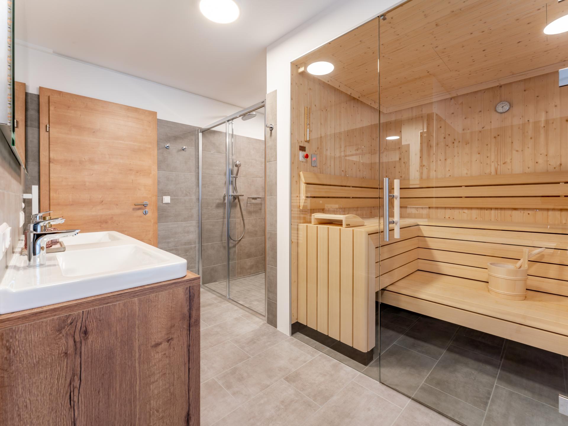 Luxuriöse Wellness mit Sauna, Whirlpool, Doppeldusche und Waschbecken im Chalet Haus Erna in Österreich